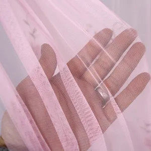 Vue rapprochée de tissu de rideau en tulle rose à double couche avec une texture douce.