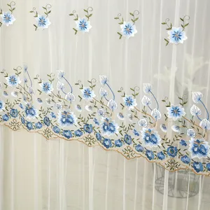 Gros plan sur le rideau transparent blanc élégant avec de délicates broderies de fleurs.