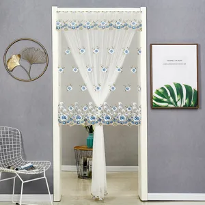 Vue détaillée du rideau de porte en dentelle transparente blanche avec broderie florale bleue.