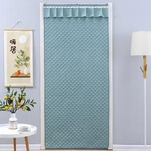 Dettagli tenda per porta termica, tessuto trapuntato blu verde con elegante bordo.