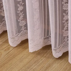 Close up view of pink lace fabric dust curtain showcasing delicate floral pattern design.