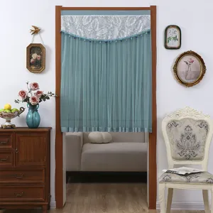 Detailed view of blue mesh door curtain featuring elegant printed valance and beaded fringe.