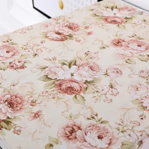 Detailansicht des floralen Abdeckungsstoffes mit rosa Rosenmuster und feiner Spitzenborte.