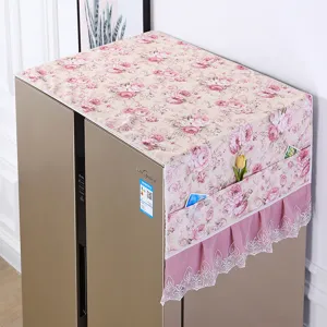 Nahaufnahme der floralen Kühlschrankabdeckung mit Spitzenborte und praktischen Taschen.
