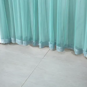 Teal sheer curtain detail close-up showing light fabric and decorative hem design.