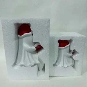 Luce notturna a fantasma con cappello di Natale rosso e libro nella confezione
