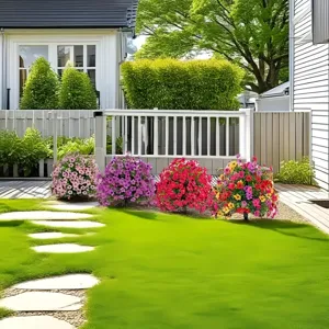 Bunte künstliche Gänseblümchen-Gartenkugeln schmücken einen grünen Rasen am Steinweg.