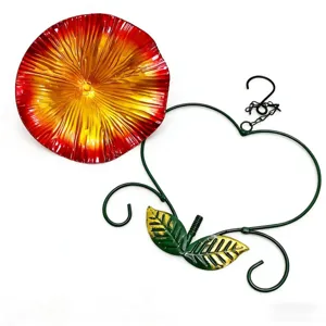 Detail view of heart-shaped iron bird feeder with vibrant red and yellow flower bird seed dish