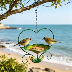 Macro view of heart-shaped iron bird feeder hanging on a beach with wild birds
