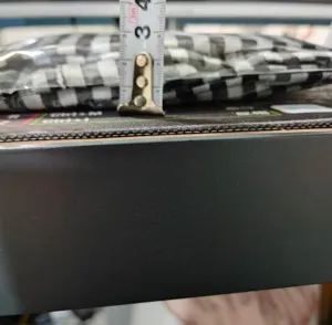 Mesure de l'épaisseur d'une jupe de four faite à la main avec un motif à carreaux noirs et blancs