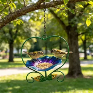 Heart-shaped hanging iron bird feeder with blue flower seed tray in a garden setting