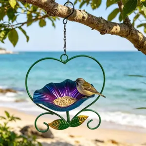 Detail of heart-shaped metal bird feeder with a small bird in a sunny garden