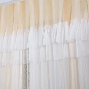 Close-up detail of layered ruffle sheer curtain, light yellow and white sheer net fabric texture.