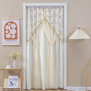 Detailansicht des doppellagigen Spitzentürvorhangs mit Blumenstickerei und eleganten Raffbändern.