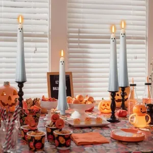 Close-up of white ghost LED candles in a festive Halloween party table setting