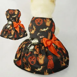 Dettaglio vestito di Halloween per cane con stampa zucca, tessuto nero e fiocco arancione.
