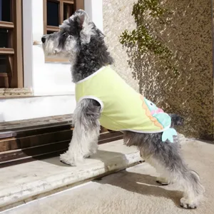 Detail view of the cute yellow pet vest with cartoon fin design worn by dog outdoors.