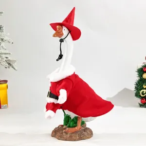 Vue détaillée rapprochée de la figurine d'oie de Noël avec chapeau rouge et cape festive.