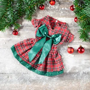 Christmas pet plaid dog dress detail view featuring green bow and festive holiday rustic background.