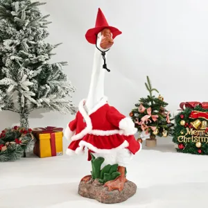 Gros plan détaillé de la mignonne statue d'oie de Noël portant une cape et un chapeau de Père Noël.