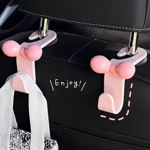 Close-up detail of the cute pink bow car seat hook installed on headrest for interior storage.
