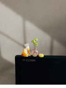 Vue détaillée d'une figurine de chat floqué et de vase miniature, jolie déco de bureau.