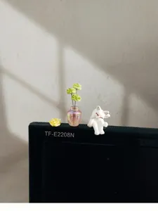 Détail en gros plan d'un ornement miniature de chat et fleurs pour le tableau de bord auto.