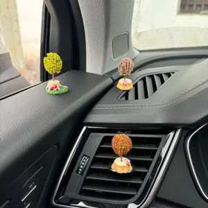 Vista di dettaglio ornamento auto mini albero micro paesaggio cruscotto e bocchetta resina.