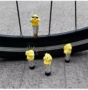 Close-up detail of cute yellow duck bicycle tire valve caps, creative accessory design.