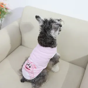 Detail shot of a cute dog wearing a pink pet vest with a fun monster print and cute text.