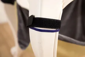 Dettaglio amaca per gatti con cinturino in velcro nero e fascia di fissaggio per sedia.
