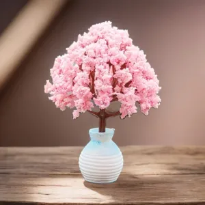 Vista detallada del árbol de flores de cerezo artificial en un jarrón azul para decoración.