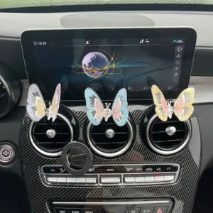 Detail view of decorative butterfly air vent clips installed on car dashboard, close up.