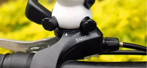 Bicycle handlebar decorated with a cute panda ornament and a Shimano brake component.