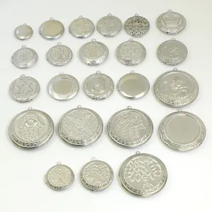 Vue détaillée de pendentifs médaillons ronds en acier inoxydable avec reliefs 3D.