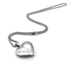 Pendentif médaillon cœur en acier inoxydable collier détail avec motif tour Eiffel gravé.