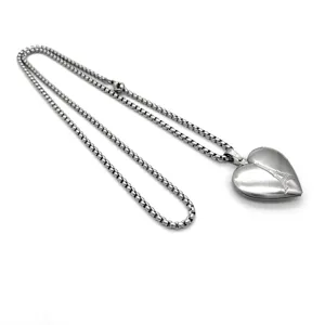 Vue detaillee du collier avec medaillon en coeur en acier inoxydable grave tour Eiffel.