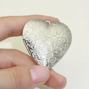 Pendentif médaillon cœur argenté avec motif floral gaufré vintage style rétro chic.