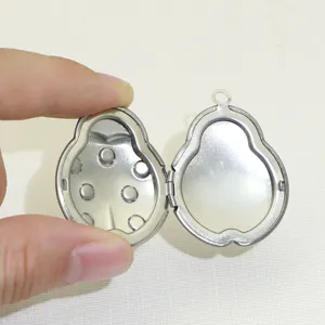 Détail du pendentif médaillon en acier inoxydable montrant la structure interne et les points.