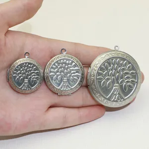 Détail de pendentif médaillon rond en acier inoxydable avec arbre en trois tailles.