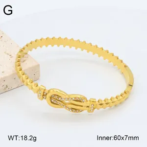 Vue détaillée du bracelet en acier inoxydable doré avec boucle en strass et bords dentelés.