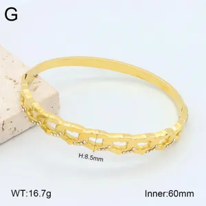 Bracelet jonc ouvert en acier inoxydable plaqué or 18K avec des détails de cristaux.