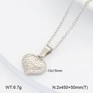 Détail de collier pendentif cœur en acier inoxydable, texture martelée, bijou minimaliste.