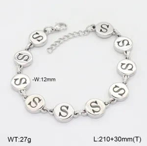 Vue de détail en gros plan du bracelet à maillons en acier inoxydable poli avec breloque lettre S.