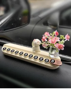 Primer plano de tarjeta de estacionamiento temporal de coche con conejito y mini florero.
