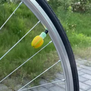 Détail du bouchon de valve de pneu de vélo, accessoire déco jaune et vert créatif.