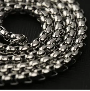 Gros plan détaillé du collier chaîne en acier titane vintage aux maillons géométriques facettés.