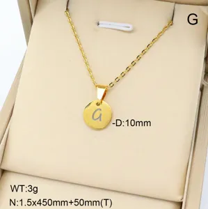 Gros plan d'un collier pendentif lettre en acier inoxydable doré présenté dans une boîte.