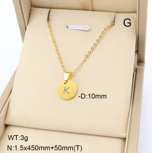 Vue détail d'un collier pendentif lettre K en acier inoxydable doré minimaliste en boîte.