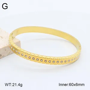 Bracelet jonc en acier inoxydable doré avec cœur et strass, détail de taille et poids.